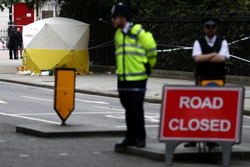 شرطيان يقفان قرب خيمة نصبها خبراء المعمل الجنائي في موقع هجوم بسكين في ميدان بوسط لندن - رويترز