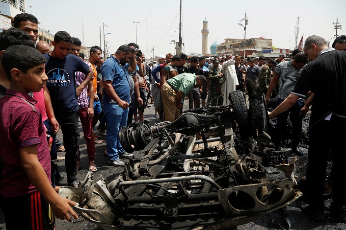 عراقيون في موقع تفجير السيارة المفخخة ببغداد (رويترز)