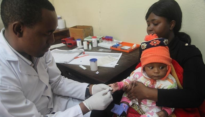 طبيب يفحص طفلا للكشف عن الملاريا في مستشفى في تنزانيا