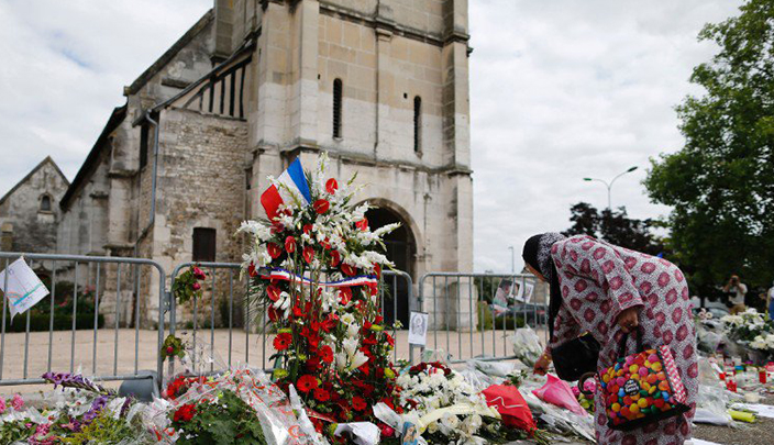 مسلمة تضع الزهور في موقع هجوم على كنيسة نورماندي 