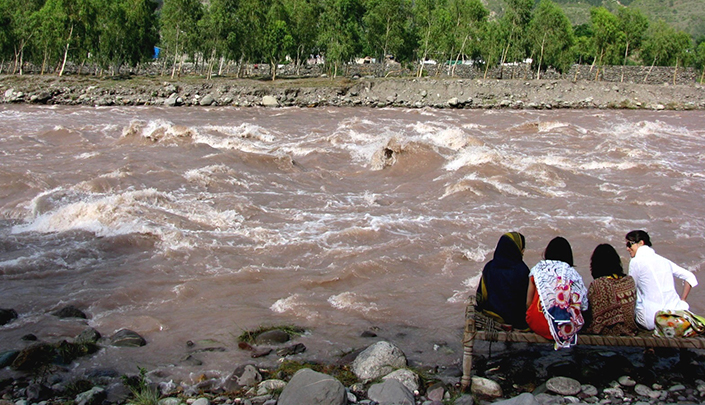 عائلة تجلس على ضفاف نهر كونهار الجارف (أرشيفية)