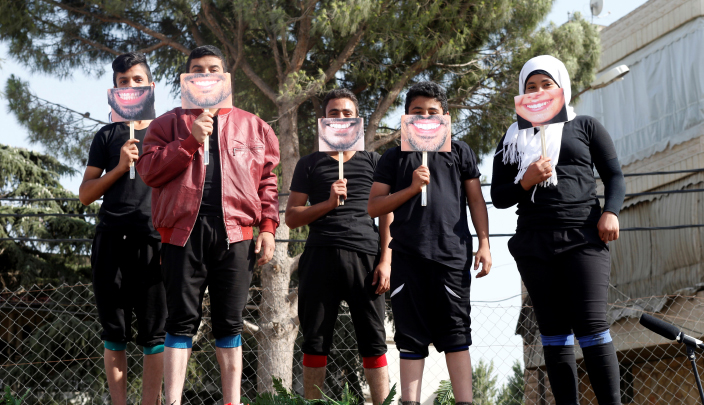 أطفال لاجئون سوريون يشاركون في مسرح الشارع بأحد مخيمات اللاجئين في لبنان