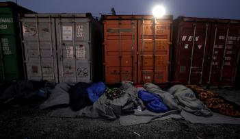 مهاجرون ينامون بجوار حاويات بالقرب من الحدود المقدونية اليونانية - رويترز