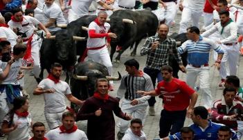 أشخاص يركضون أمام ثيران في مهرجان سان فيرمين في بامبلونا بشمال إسبانيا