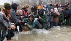 بالصور.. آلاف المهاجرين يعبرون نهرا خطيرا للوصول إلى مقدونيا