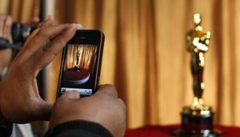 شخص يلتقط صورة لتمثال الأوسكار في نيويورك