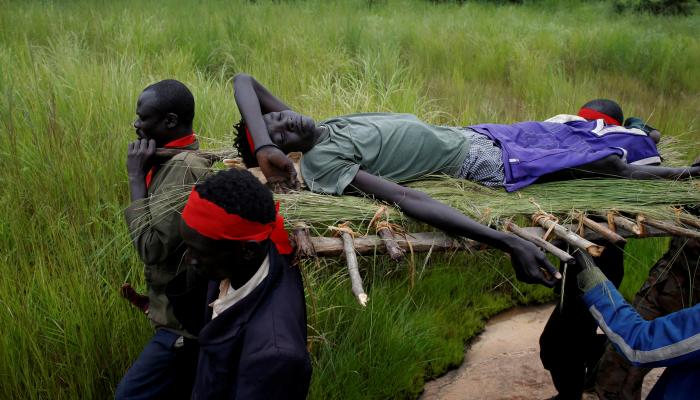 مقاتلون يحملون جريحا في جنوب السودان (رويترز)