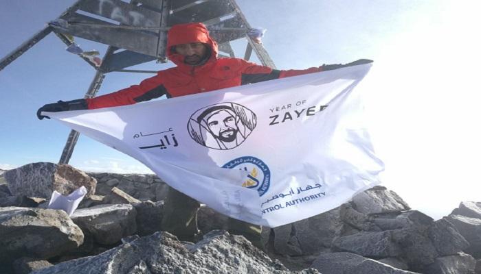 المغامر الإماراتي راشد اليافعي يرفع شعار عام زايد على قمة جبل