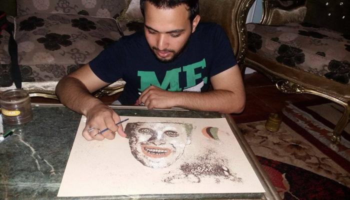 أحمد رجب يرسم إحدى لوحاته