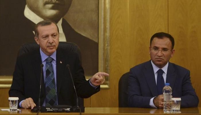 وزير العدل التركي بجانب أردوغان (رويترز)