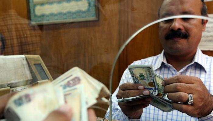 مصري يُبدل دولارات أمريكية بجنيهات مصرية