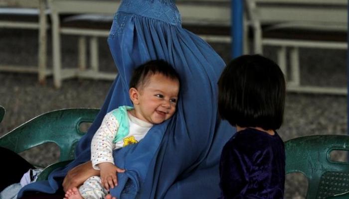 لاجئة أفغانية تنتظر مع طفليها ترحيلها إلى أفغانستان