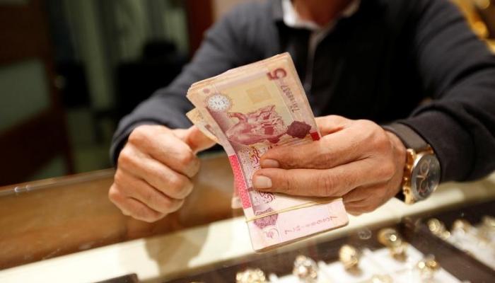 رجل يعد دنانير ليبية في شركة للصرافة في طرابلس