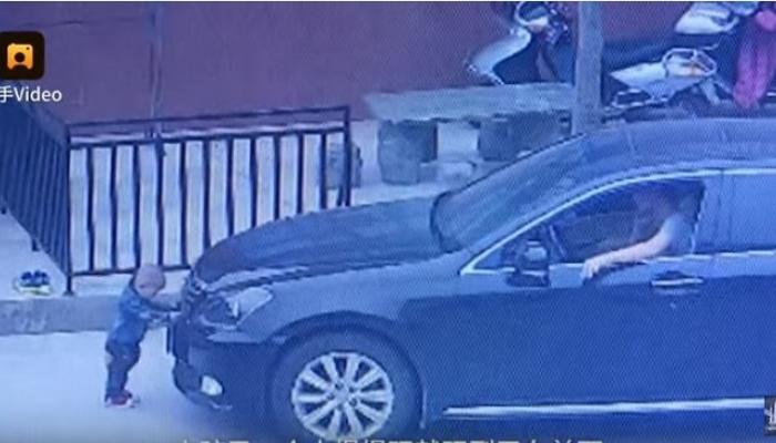 الطفل الصيني أثناء وقوفه أمام السيارة