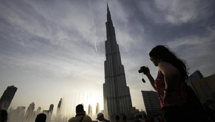 سائحون يلتقطون صورا لبرج خليفة في دبي 