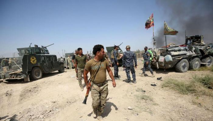 مسلحين من مليشيا الحشد الشعبي يركبون دبابة فى العراق 