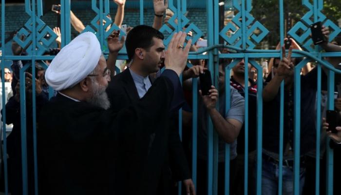 روحاني يلوح لأنصاره من خلف سياج حديدي (رويترز)