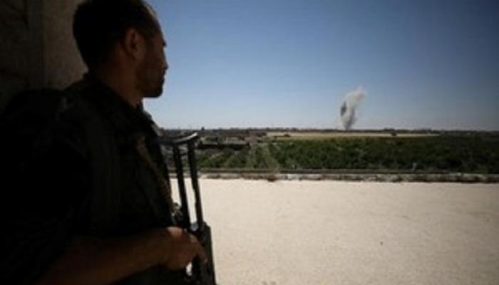 مقاتل من قوات سوريا الديمقراطية يتابع تصاعد دخان من حي المشلب بالرقة