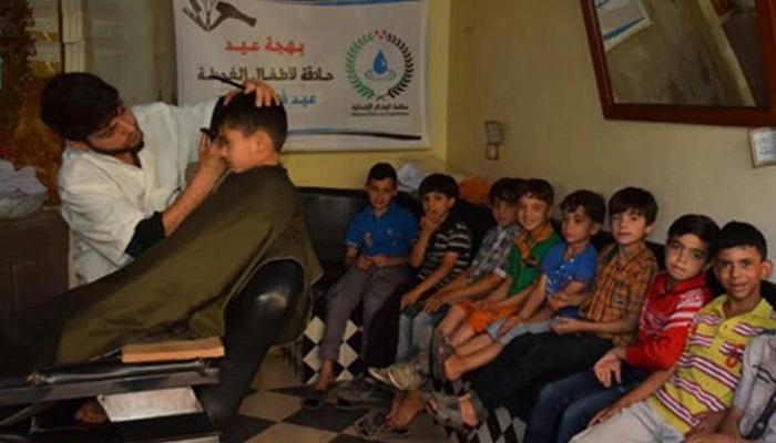 الأطفال ينتظرون دورهم في الحلاقة المجانية