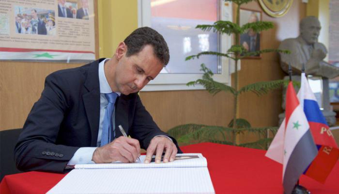 الأسد يكتب كلمة في سجل الزيارات بالقاعدة الروسية