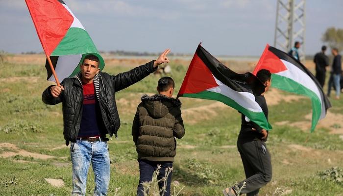 شباب يحملون الأعلام الفلسطينية في مسيرة بغزة- أرشيفية