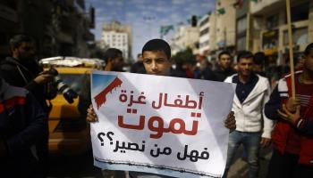شاب فلسطيني يرفع لافته أثناء إضراب غزة
