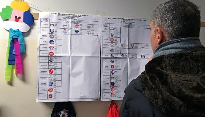 ناخب إيطالي يفاضل بين المرشحين قبل التصويت في الانتخابات - رويترز