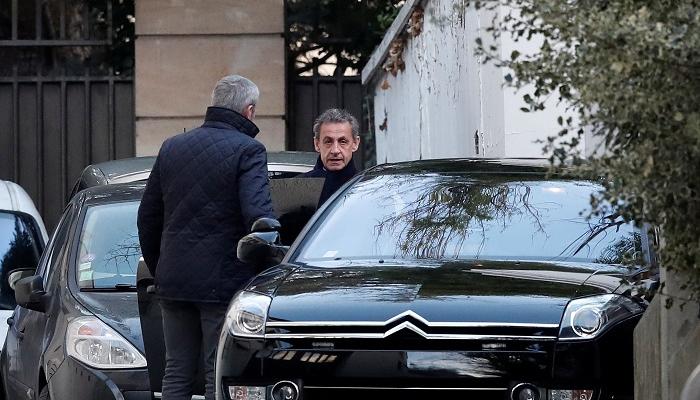 ساركوزي لدى مغادرته في طريقه لاستكمال التحقيق معه- أ.ف.ب