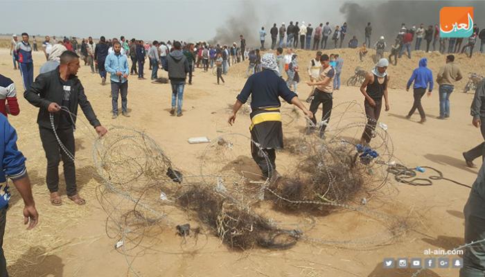 متظاهرون ينزعون السلك الشائك قرب الحدود مع إسرائيل