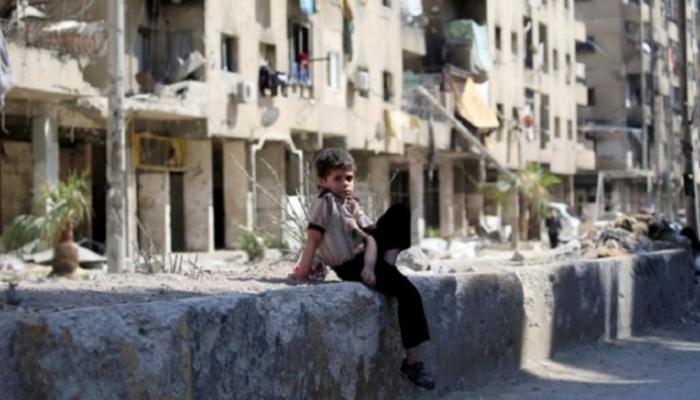 طفل سوري وسط آثار الدمار في مدينة دوما قرب دمشق