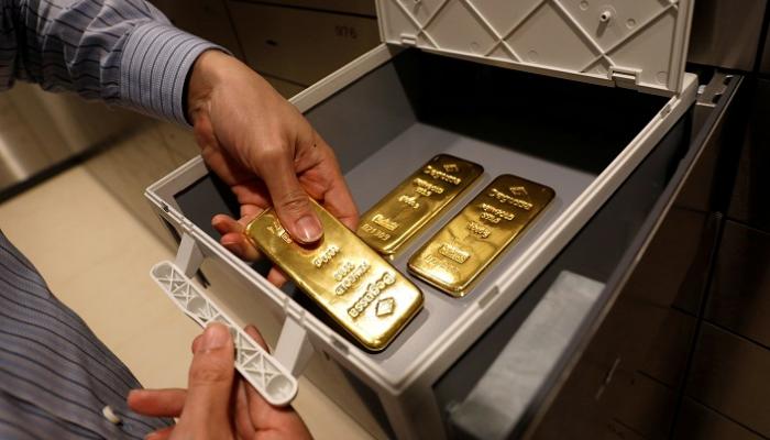 موظف يضع سبائك ذهبية في صندوق ودائع آمن في متجر بسنغافورة