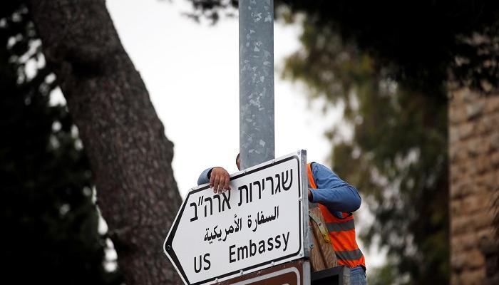 أحد العمال يعلق لافتة السفارة الأمريكية بالقدس- رويترز
