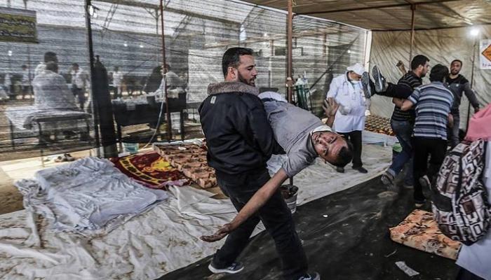 فلسطيني يحمل شهيد قتل برصاص الاحتلال