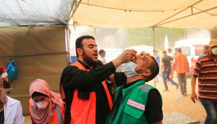 مسعف فلسطيني يعالج زميله الذي أصابته قوات الاحتلال الإسرائيلي