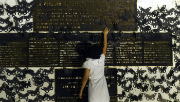 امرأة تلامس لوحة تذكارية أثناء مظاهرة تحيي ذكرى نساء قتلى في السلفادور