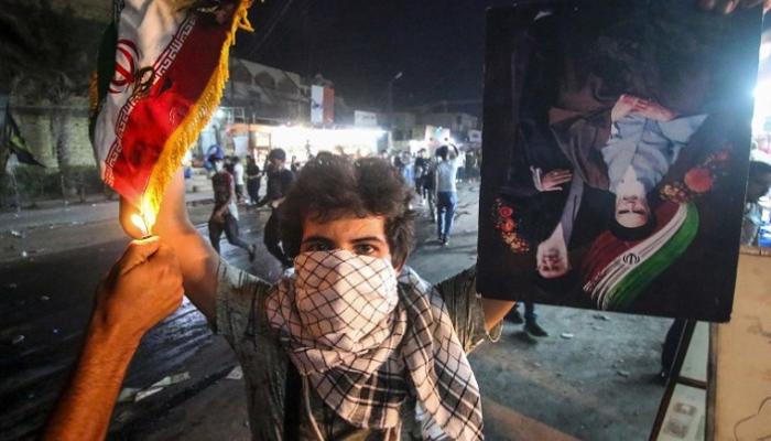 شاب عراقي يحرق العلم الإيراني خلال مظاهرات البصرة - أ.ف.ب