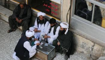 تجار أفغان يعدون العملات في سوق المال بهرات