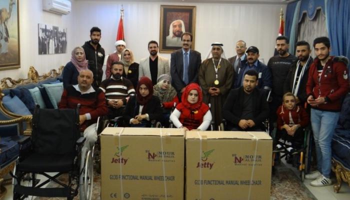 السفير الإماراتي لدى العراق أثناء توزيع الكراسي المتحركة