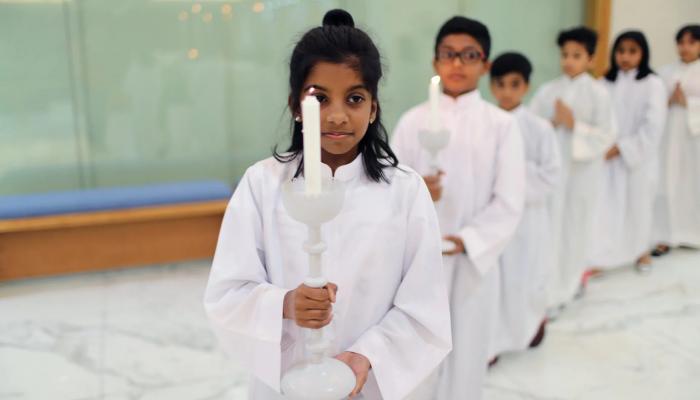 أطفال يحملون الشموع في كنيسة القديس فرنسيس الأسيزي بدبي