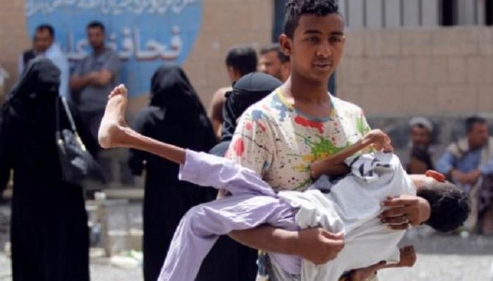 صبي نازح من مدينة الحديدة يحمل شقيقه المصاب- رويترز