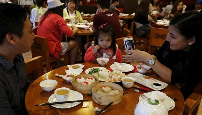 عائلة تتناول الطعام في مطعم صيني- رويترز