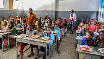 الصورة أثناء تقديم وجبة الغداء للتلاميذ