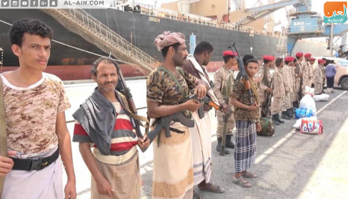 عناصر حوثية بزي مدني قبل تسليم الميناء لآخرين بملابس خفر السواحل