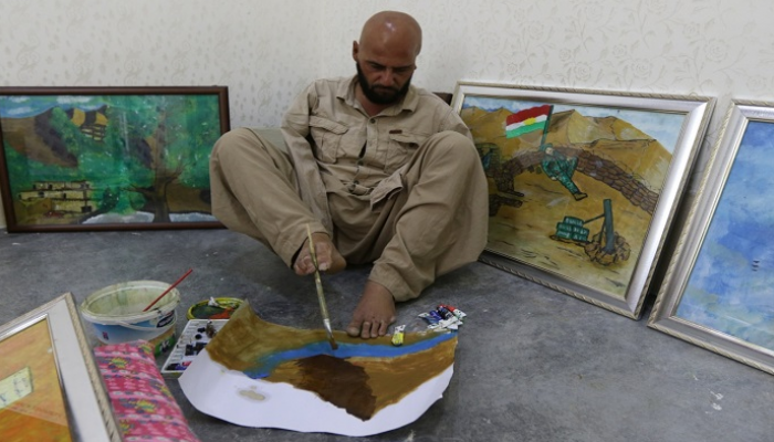 الفنان العراقي أراس عثمان يرسم بقدميه بعد أن فقد ذراعيه في حادث