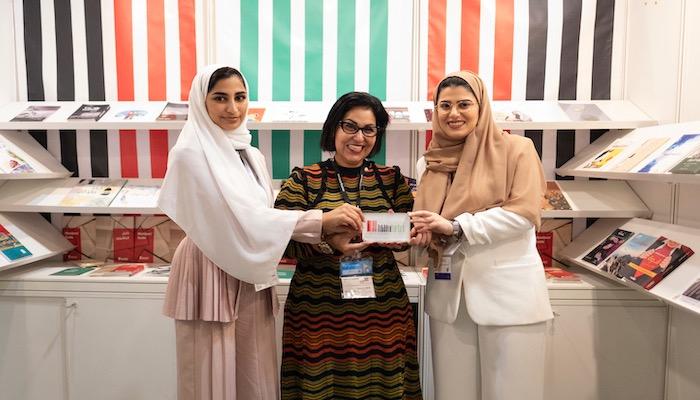 نبيلة الشامسي مع فريق جمعية الناشرين الإماراتيين في المعرض
