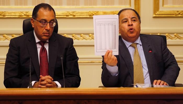 وزير المالية المصري يلوح بورقة بجوار رئيس الوزراء - رويترز