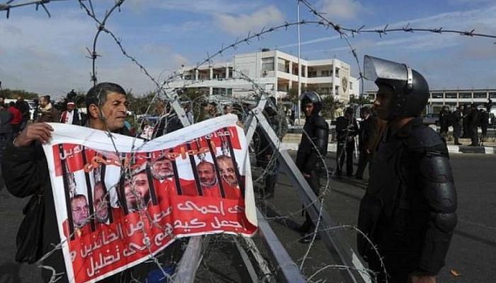 متظاهر يحمل لافتة تطالب بحماية مصر من إرهاب الإخوان