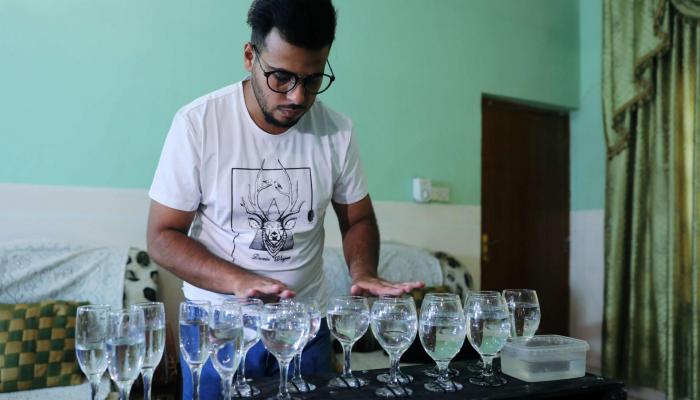 الطالب العراقي سجاد محمود أمام كؤوسه الزجاجية