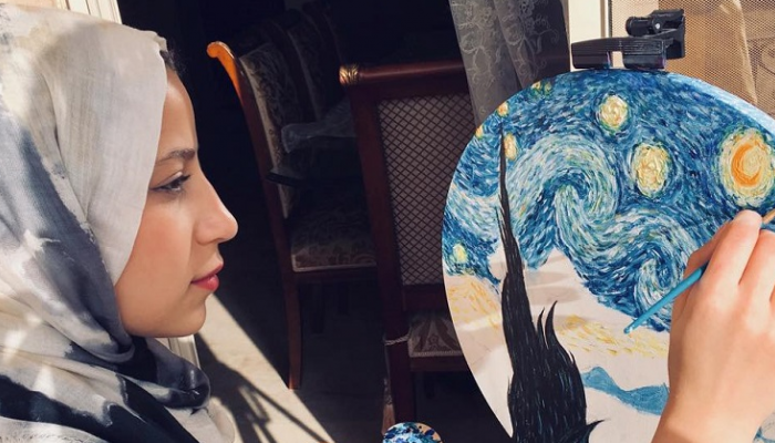 يُمنى هشام ترسم إحدى لوحاتها