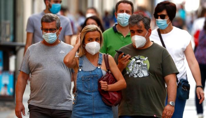 مارة يرتدون كمامات للوقاية من كورونا في مدريد